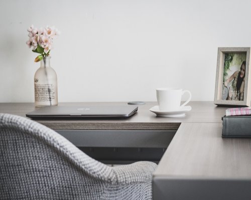 A person stretching at their home office desk